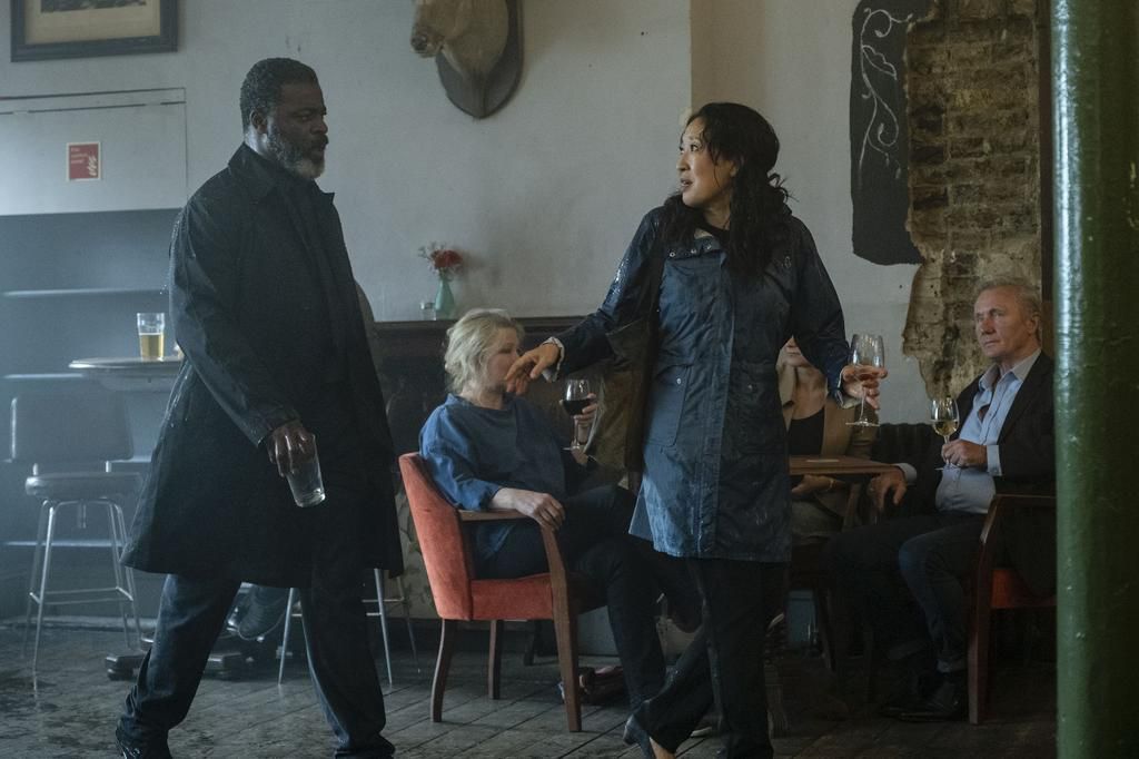 Danny Sapani and Sandra Oh in a scene from 'Killing Eve.' They are having an argument in a bar where Kenny's funeral is being held and Eve is walking away.