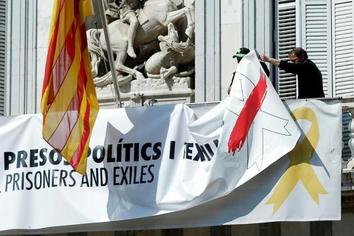 Barcelona City Hall officials taking down a banner bearing that reads lFreedom for political prisoners and exiles' last March