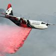 A C-130 Hercules plane from the New South Wales Rural Fire Service dropping fire retardent on bushfires