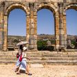 Tourists walk through the ruins of the ancient Roman site of Volubilis, near the Moroccan city of Meknes