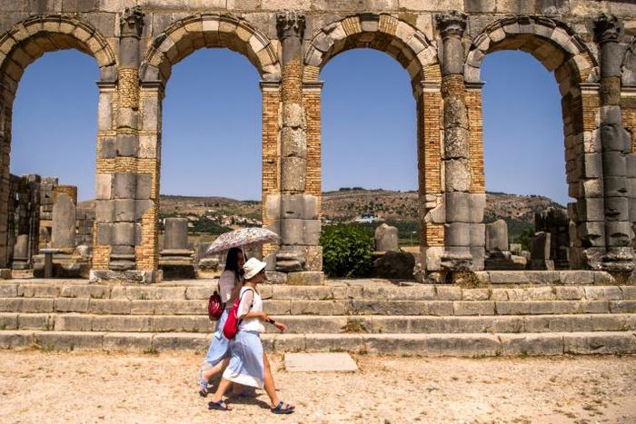 Tourists walk through the ruins of the ancient Roman site of Volubilis, near the Moroccan city of Meknes