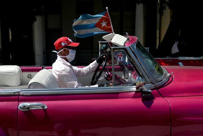 The driver of a vintage American car wears a face mask while taking tourists around Havana -- but Cuba is to close to visitors over the coronavirus outbreak