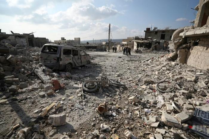 Residents check the damage following reported air and helicopter raids by Russian and Syrian regime forces in the town of Al-Bara in the south of Syria's Idlib province on December 7, 2019.