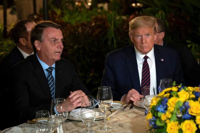 (FILES) In this file photo US President Donald Trump (R) speaks with Brazilian President Jair Bolsonaro during a dinner at Mar-a-Lago in Palm Beach, Florida, on March 7, 2020