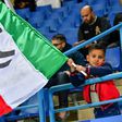 A young Juventus supporter waves the Italian flag.