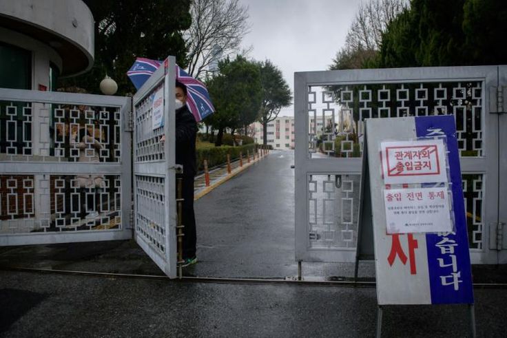 A security guard stands at the entrance to an apartment complex reserved for young, poor women, which has seen nearly a third of its 142 residents test positive for the coronavirus, in Daegu