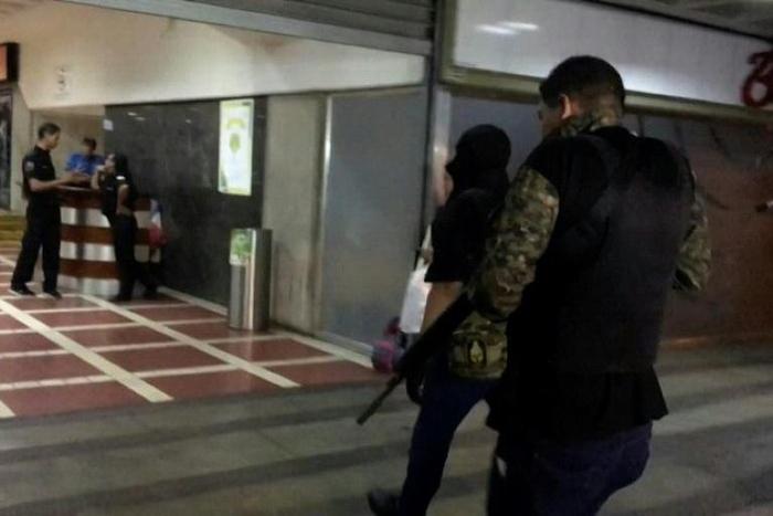 A video grab taken from AFP TV footage shows unidentified armed and hooded men walking into opposition leader Juan Guaido's party headquarters in Caracas, Venezuela