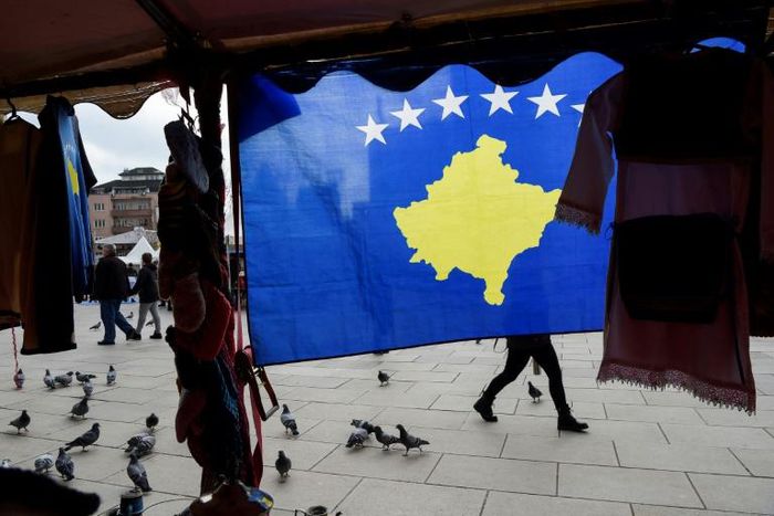 A pedestrian walks behind the Kosovo flag ahead of last year's 10th-anniversary celebrations in Pristina of Kosovo's declaration of independence