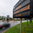 A car drives past a sign reading " red weather alert at 2pm" in Nice