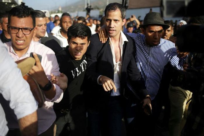 Venezuela's self-proclaimed acting president Juan Guaido (C) is seen being escorted to his car on February 11, 2020, upon arrival at the international airport near Caracas, after a foreign tour; authorities detained his uncle