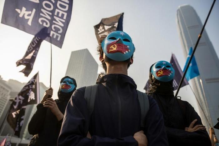 Some protesters at a rally for China's Uighurs in Hong Kong wore blue face masks with the flag of East Turkestan, the term many Uighur separatists use for Xinjiang