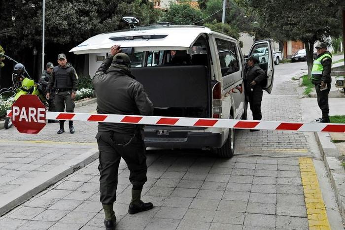 Police officers check a car at the entrance of La Rinconada gated community, where the Mexican embassy is located, in La Paz, after Mexico was accused of colluding with Spanish diplomats to whisk a wanted Bolivian ex-minister out of the embassy