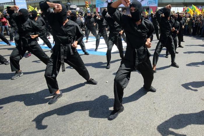 Iraqi Shiite fighters from the Iran-backed Hezbollah brigades take part in a military parade to mark the pro-Palestinian Al-Quds (Jerusalem) Day in Baghdad in May this year