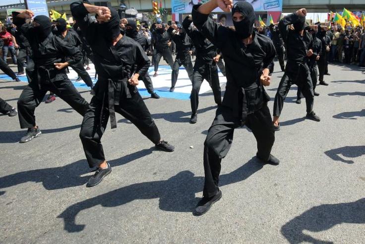 Iraqi Shiite fighters from the Iran-backed Hezbollah brigades take part in a military parade to mark the pro-Palestinian Al-Quds (Jerusalem) Day in Baghdad in May this year