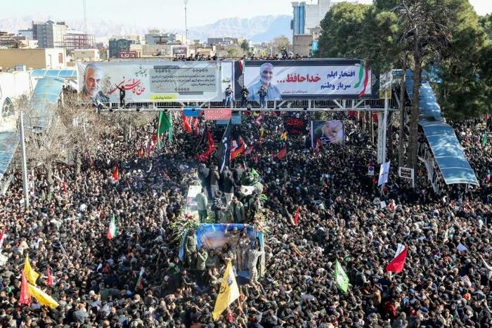Iranian mourners gather around a vehicle carrying the coffin of slain top general Qasem Soleimani during the final stage of funeral processions, in his hometown Kerman