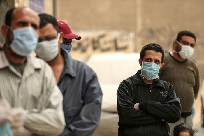 Egyptian men wait outside a food bank, after movement restrictions imposed to fight coronavirus crippled already precarious livelihoods