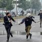 A policeman chases a lawyer following the clash at a Lahore cardiac hospital