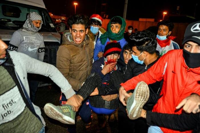 Iraqis carry an injured anti-government protester during clashes with security forces in the central holy shrine city of Najaf on November 28, 2019