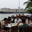 Diners have lunch in the foreground of the Westerdam cruise ship in Sihanoukville