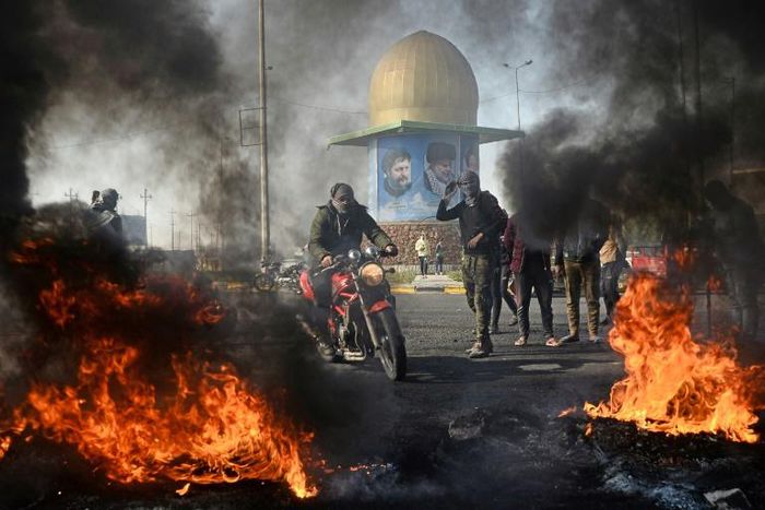 Iraqi protesters block the airport highway in the Shiite shrine city of Najaf, a major draw for foreign pilgrims