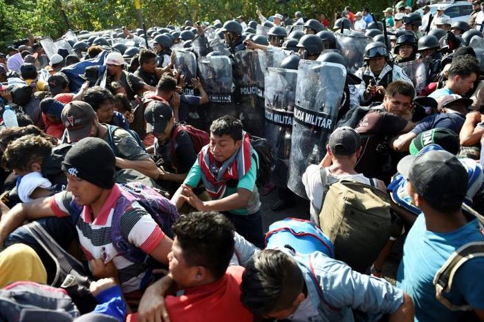Members of the Mexican National Guard scuffle with Central American migrants - mostly Hondurans heading in a caravan to the US - in Ciudad Hidalgo, Chiapas State on Thursday