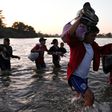 Central American migrants -- mostly Hondurans heading to the US in a caravan -- cross the Suchiate River from Tecun Uman, Guatemala, to Ciudad Hidalgo, Chiapas State, Mexico, on January 23, 2020