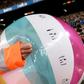 A staff member removes an inflatable ball thrown by Barcelona supporters on to the pitch