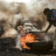 Anti-government protesters cut off a road with flaming tyres during a demonstration against Iraq's prime minister-designate Mohammad Allawi in the shrine city of Najaf, south of the capital