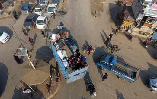 Syrian families flee the village of Hazano, about 20 kilometres northwest of the city of Idlib, towards the Turkish border on Sunday, after the regime stepped up advances against jihadists