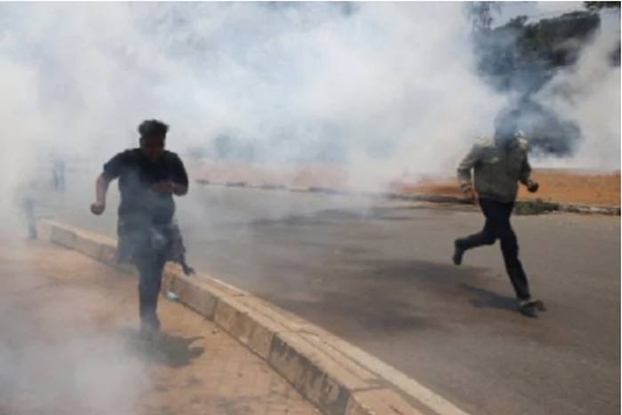 Kenyan police enforcing lock-down take to their heels as residents chase them up with teargas