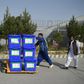 Independent Election Commission workers carry ballot boxes to a counting centre after the September poll