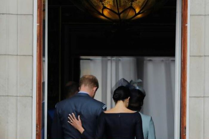 (FILES) In this file photo taken on July 10, 2018 Britain's Meghan, Duchess of Sussex (R) puts her hand on Britain's Prince Harry, Duke of Sussex's back; Britain's Prince Harry and his wife Meghan will give up their titles and stop receiving public fun...