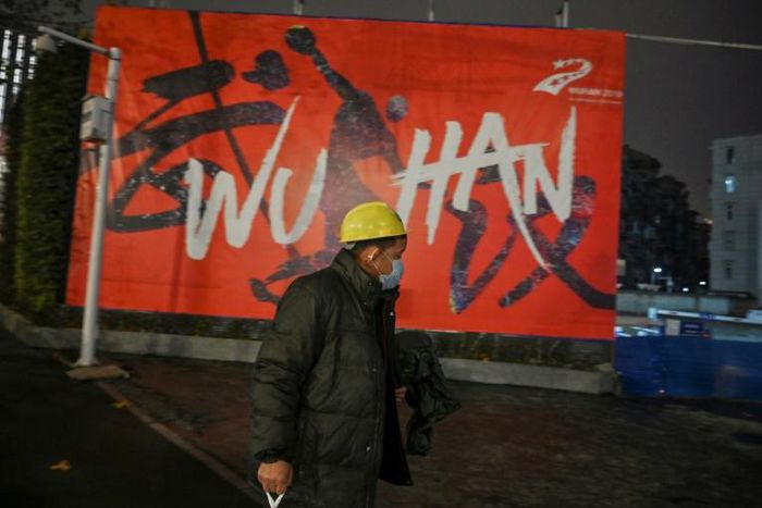 A man wearing a protective facemask walks along a street in Wuhan on January 26, 2020, a city at the epicentre of a viral outbreak that has killed at least 56 people and infected nearly 2,000
