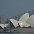 The Sydney Opera House and Harbour Bridge are seen through a smokey haze blanketing the city