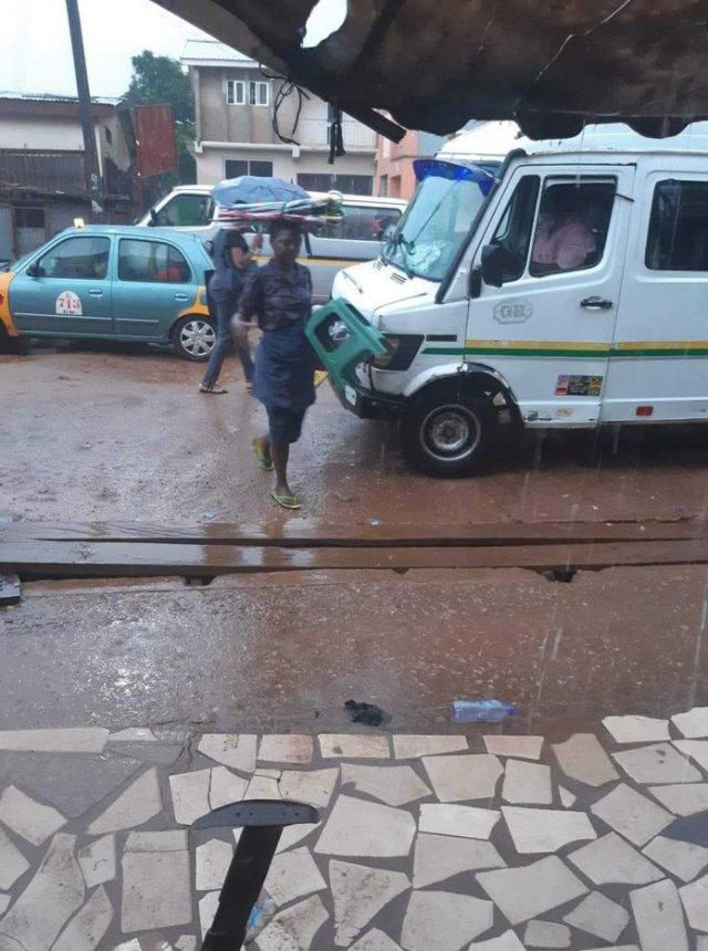 Umbrella seller refuses to use one of her umbrellas to protect herself against rain