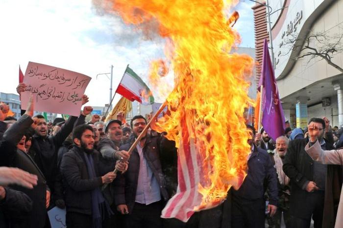 Iranian men burn a US flag during a protest in support of the Islamic republic's government and supreme leader Ayatollah Ali Khamenei