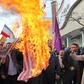 Iranian men burn a US flag during a protest in support of the Islamic republic's government and supreme leader Ayatollah Ali Khamenei