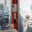 Medical workers wearing a face make and protection gear tend to a patient inside the new coronavirus intensive care unit of the Brescia Poliambulanza hospital as the town saw the country's highest daily rise in case numbers