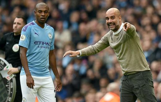 Manchester City manager Pep Guardiola gives instructions to Fernandinho