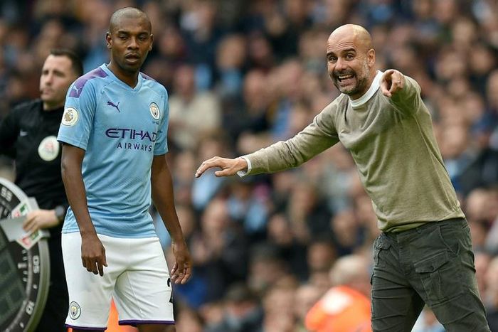Manchester City manager Pep Guardiola gives instructions to Fernandinho