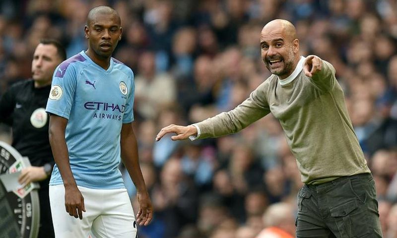 Manchester City manager Pep Guardiola gives instructions to Fernandinho