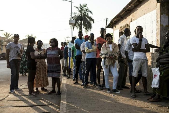 People wait to cast their vote in Bissau, the capital