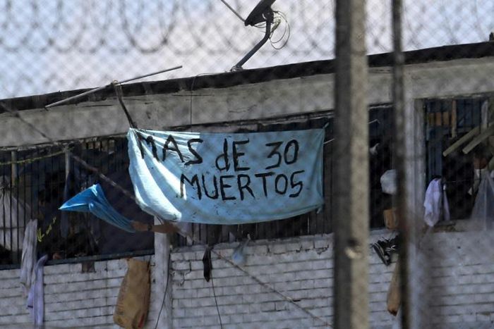 Inmates at Bogota's La Modelo prison hold up a sign saying, "More than 30 Dead" after a night of rioting in one of Colombia's biggest prisons, on March 22, 2020