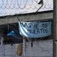 Inmates at Bogota's La Modelo prison hold up a sign saying, "More than 30 Dead" after a night of rioting in one of Colombia's biggest prisons, on March 22, 2020