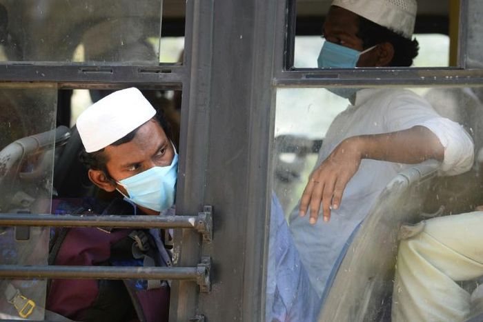 Men in facemasks wait on a bus taking them to a quarantine facility after they attended an Islamic gathering which has turned out to be a hotspot for Coronavirus infections in Nizamuddin, New Delhi