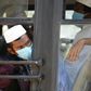 Men in facemasks wait on a bus taking them to a quarantine facility after they attended an Islamic gathering which has turned out to be a hotspot for Coronavirus infections in Nizamuddin, New Delhi