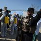 An Afghan policeman gestures as volunteers wearing a hazmat suits and a facemasks gather before the start of a preventive campaign against the spread of the COVID-19 coronavirus, in Kabul on March 18, 2020