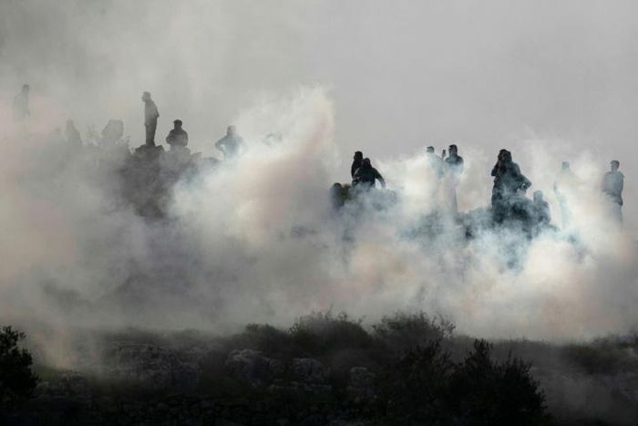 Young Palestinians brave Israeli tear gas to demonstrate against a rumoured land seizure near the northern West Bank city of Nablus