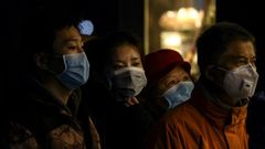 People wearing protective facemasks queue for food in Shanghai