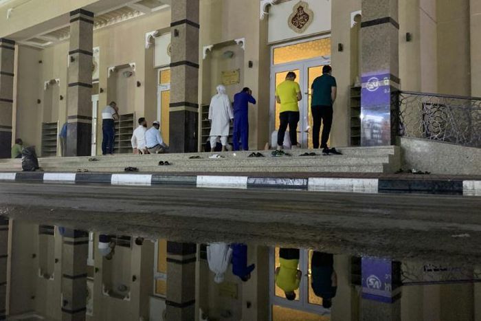 Muslim worshippers pray in front of a Dubai mosque, one of many places of worship across the region to close its doors